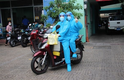 Nhân viên y tế đi xe máy đến tận nhà dân tiêm vắc xin COVID-19